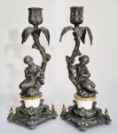 ALEMANHA, PERÍODO GRÜDERZEIT (1871-1918) - Par de candelabros alemães; colunas representado casal fidalgo sob árvore tropical. Partes em bronze e estanho, detalhe em porcelana branca. Alt. 31cm. Falta uma folha (bobeche pode ser substituida conforme similar foto1) --- VER SIMILARES -  https://antik-und-stil.com/produkt/2-antike-gruenderzeit-kerzenhalter-figuren-bronze-floral-19-jh/  -------https://www.ebay.co.uk/itm/126291056891