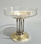 ART DECO - Circa de 1900/1930 - Antigo centro de mesa em metal banhado a prata, suspenso por quatro colunas. Bojo original em vidro lapidado. desgastes no banho. Marca não localizada. Alguns bicados na borda.  Med. 20 x 21 cm.