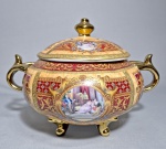 Terrina com tampa, ricamente ornamentados em tons de vinho e dourado com aplicações em relevo e cenas galantes centrais, alças e pés com acabamento dourado; Med.
