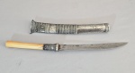 BURMA/MYANMAR - Séc.XIX/XX - Antiga adaga DHA-HMYAUNG, tradicional do sudoeste asiático. Lâmina forjada a mão, cabo em marfim/osso. Bainha e acabamentos em prata cinzelada e adornada com roseta. Fissuras e marcas do tempo compátiveis com a idade e uso. Medida total: 36 cm. --- VER SIMILARES E COTAÇÕES ---- https://tibetankeepsakes.com/products/a-burmese-dagger  ------ http://www.pralanna.com/shoppage.php?shopid=974376 ------https://petermustonen.com/product/burmese-dha-short-sword/