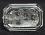 Antigo cinzeiro com tampa em cristal europeu incolor, delicadamente lapidado com cena clássica com figuras femininas. Alguns pequenos bicados na borda. Med. 9.5 x 7.5 x 5 cm
