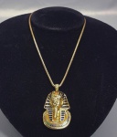 Colar e pingente folheado a Ouro e esmalte, representando a máscara de Ouro do faraó Tuthankamon. Med. 49 cm aberto e 5 cm