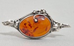 Broche em prata adornado com grande cabuchon em Ambar do baltico. Meed. 6 x 2.5 cm