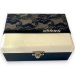 CAIXA PORTA-JOIAS EXECUTADO EM MADEIRA REVESTIDA EM COURINO E RENDA, TAMPA COM MOVIMENTO BASCULANTE, FUNDO ESPELHADO, INTERIOR REVESTIDO EM TECIDO AVELUDADO, MEDINDO 9 X 22 X 16 CM.