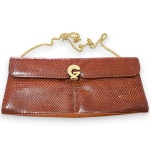 VIBORA - BOLSA CLUTCH, MADE IN ARGENTINA, CONFECCIONADA COURO COM DECORAÇÃO EM PELE DE COBRA, COR MARROM, ALÇAS EM METAL DOURADO, MEDINDO 13 X 28 CM. TRATA-SE DE PEÇA SEMINOVA, PODENDO APRESENTAR SINAIS DE USO, MARCAS DO TEMPO, DESGASTES NATURAIS, PEQUENAS IMPERFEIÇÕES, RESTAUROS, REPAROS E/OU OUTRAS CARACTERÍSTICAS PRÓPRIAS DE SUA NATUREZA, USO E ESTADO DE CONSERVAÇÃO, NÃO SENDO TAIS ASPECTOS, POR SI SÓ, MOTIVO PARA DESCLASSIFICAÇÃO, CANCELAMENTO OU QUESTIONAMENTOS POSTERIORES, DEVENDO O ARREMATANTE CONSIDERAR TAIS CONDIÇÕES PREVIAMENTE À OFERTA E ARREMATAÇÃO.