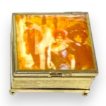 CAIXA PORTA JÓIAS, EXECUTADA EM METAL DOURADO, ORNADA COM ESPELHO NO VERSO DA TAMPA, INTERIOR AVELUDADO, MEDINDO 4 X 7 X 7 CM.