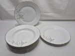 Jogo de 6 pratos em porcelana Beatriz, floral, relevos na borda e friso prata, composto de 4 fundos e 2 rasos. Medindo o de sopa 23cm de diâmetro, mesa 24cm de diâmetro. Desgaste no friso.