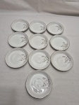Jogo de 10 pires de café em porcelana Beatriz, floral, relevos na borda e friso prata. Medindo 11cm de diâmetro.