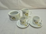 Lote de açucareiro sem tampa, leiteira e 2 xícaras de café em porcelana Renner, flor amarela e friso ouro. Medindo a leiteira 9,5cm de altura. Leve bicado no açucareiro.