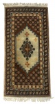 Tapete persa antigo, tecido manualmente em lã, com desenho de nicho (mihrab) central e rica composição geométrica. Paleta em tons terrosos, bege e castanho, com bordaduras elaboradas e franjas originais. Peça decorativa e colecionável, em bom estado geral de conservação. Mede 1,80 x 85 cm.