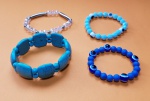 Conjunto de 4 pulseiras elásticas diversas em metal, contas e resinas