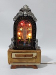 Portugal - Antigo Oratório com Luminária e Caixa Musical à corda - Representando Nossa Senhora de Fátima - '' Nossa Senhora de Fátima Abençoai esta Casa '' - Estrutura em madeira, frente de vidro com Apliques em Metal Prateado - Caixa Musical e Luminária funcionando - Conforme fotos - Medida: 26 cm  x 14 x 9 cm. OBS: Na estrutura do oratório está sem o revestimento de acabamento e possui emenda na fiação. Conforme fotos.