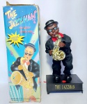Lindo Boneco Musical e Dançante - THE JAZZMAN - Funcionamento: 4 pilhas AA - Dança Simulando Tocar Saxofone emitindo uma Linda melodia de jazz. Acondicionado na caixa original. Medida da caixa: 42 cm x 19 cm x 14 cm. OBS: Foi feito teste e está funcionando, porém possui perda em um dos pés da base conforme fotos.