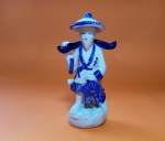 Estatueta em porcelana de pescador chinês, segurando peixes, em tons azuis - Dimensão: 15,5 X 8 cm