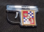 Isqueiro da marca Corona. Em formato de pistola com cabo decorado com brasão. Não testado e sem garantias de funcionamento. Medindo 4.5 x 6 cm