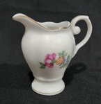PORCELANA REAL - ANTIGA LEITEIRA EM PORCELANA COM DECORAÇÃO FLORAL. MEDINDO 10.5 X 7 X 11 CM