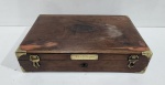 ANTIGA CAIXA EXECUTADA EM MADEIRA NOBRE E ACABAMENTOS EM METAL DOURADO COM PLAQUETA INSCRITA HISTOLOGIA. AUSÊNCIA DE UM ACABAMENTO NA TAMPA. MEDINDO 7 X 22 X 32 CM