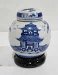 ANTIGO POTICHE EM PORCELANA ORIENTAL COM DECORAÇÃO DE PAISAGEM COM PAGODES EM TOM DE AZUL. ACOPANHA A BASE EM MADEIRA. MEDINDO 11 X 8 CM