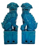 Par de "cães de fó" em porcelana oriental esmaltada na cor azul, apoiados sobre base. Mede 22cm altura.