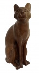 Elegante escultura em madeira maciça, representando figura de gato em posição sentada, com traços suavemente estilizados que evidenciam a serenidade felina. O entalhe revela linhas fluidas, orelhas eretas e delicados detalhes faciais, transmitindo equilíbrio e harmonia.A peça apresenta acabamento em tom natural, com leve polimento que valoriza o veio da madeira e confere um aspecto quente e acolhedor. Ideal para colecionadores de arte decorativa ou amantes de representações animais, agrega charme a ambientes contemporâneos ou clássicos. Dimensões 30 x 16 cm.Uma obra singular que une a simplicidade da forma à nobreza do material, perfeita para compor coleções de arte popular ou escultura decorativa.