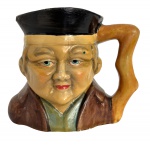 PORTUGAL - Antiga caneca figurativa, produção portuguesa, em cerâmica pintada à mão. Modelo em forma de personagem oriental, com policromia original e sinais do tempo. Peça colecionável.  Sinal de restauro. Mede 11 cm.