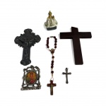 Lote com peças de devoção em diversos materiais, composto por crucifixos em metal e madeira, rosário com contas em madeira, pequena imagem sacra e mini ícone religioso em moldura metálica. Conjunto com pátina do tempo e sinais de uso. Maior peça mede 11 cm.