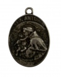 Medalha de devoção  Santo AntônioPeça antiga em metal, formato oval, com belo relevo de Santo Antônio com o Menino Jesus. No verso, oração em alto-relevo: Pela sua intercessão foge a peste, o erro e a morte; o fraco fica forte. Amém. Objeto de fé e proteção, ideal para colecionadores de arte sacra. Mede 3,5 cm.