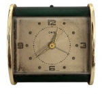 Relógio despertador de mesa Oris, fabricação suíça, estilo Art Déco, caixa em metal com laterais douradas e corpo em tom verde. Mostrador original com algarismos aplicados e mecanismo mecânico de corda. Peça antiga, com marcas do tempo e oxidação visíveis, conforme fotos. Mede 6.5 cm.