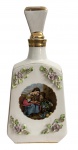 PORTUGAL Garrafa licoreira em porcelana portuguesa Real Fábrica de Alcobaça (RB  Alcobaça), decorada com cenas galantes policromadas, aplicação de flores em relevo e filetes dourados. Tampa original, inscrição lateral Brandy, peça marcada Made in Portugal, com craquelê e desgastes compatíveis com a idade. Mede26 cm.