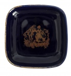 Porta alianças em pasta de porcelana francesa LIMOGES  Castel. Peça esmaltada em azul cobalto, formato quadrado, rica decoração dourada central com cena galante em estilo rococó e borda fileteada a ouro. Marca no verso Porcelaine Limoges Castel  Fabriquée et Décorée à Limoges. Mede 9 x 9 cm.