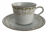 Xícara de chá com pires em porcelana japonesa Noritake, modelo Sonia, decoração floral em relevo com detalhes dourados. Peça elegante, de acabamento refinado, ideal para composição de serviço ou coleção.