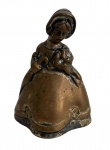 Escultura sino em bronze, representando figura feminina trajada, acabamento patinado, com badalo interno funcional. Peça decorativa de caráter artístico e sonoro, com marcas do tempo compatíveis com a antiguidade. Ideal para coleção ou ambientação clássica. Mede 7cm.
