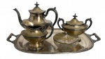 Conjunto para chá e café em metal prateado Zepter & Barton, composto por bule, açucareiro com tampa, leiteira, manteigueira em cristal lapidado com tampa metálica e bandeja oval com alças, peças de linhas elegantes e estilo clássico, início do século XX. Mede 48 x 31 cm.