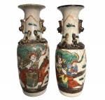 COMPANHIA DAS INDIAS - Importante par de vasos em porcelana oriental, atribuído à Companhia das Índias, decorados em policromia com cenas figurativas de guerreiros a cavalo e personagens em paisagem. Corpo cilíndrico com gargalo alargado, aplicações em relevo na parte superior e esmaltação com craquelê natural do tempo. Mede 19 cm.