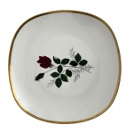 BAVARIA - Fruteira em porcelana alemã Bavaria  Schumann Arzberg, formato quadrado com bordas arredondadas, decoração floral com rosa vermelha ao centro e filete dourado na borda. Peça elegante, de bom acabamento, com marca no verso. Mede 26 cm.