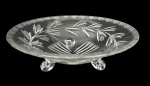 Centro de mesa em cristal lapidado, formato circular, com decoração vegetal em lapidação profunda e borda trabalhada. Apoiado sobre três pés integrados, peça elegante e decorativa, adequada para mesa ou aparador. Bom estado geral. Medida 24,cm de diâmetro.
