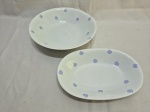 Jogo de 2 travessas em porcelana Renner estampada, sendo uma redonda e uma oval. Medindo a redonda 24cm x 6cm de altura.