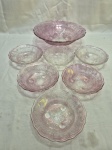 Jogo de bowl com 6 cumbucas em vidro lilás moldado. Medindo o bowl 24,5cm x 7cm de altura, cumbuca 12,5cm x 5cm de altura. Com leve perda no esmalte.