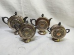 Antigo jogo de servir chá, café com 4 peças em metal espessurado à prata com relevos. Medindo o bule maior 18cm de altura. Banho com desgaste, leve mossa.