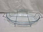 Travessa oval em vidro temperado com suporte em metal prateado. Medindo a travessa 39,5cm x 28cm x 6,5cm de altura.