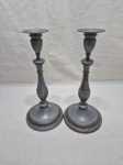 Par de castiçais em metal prateado com relevos. Medindo 13,5cm de base x 29cm de altura.