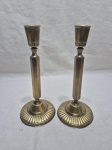 Par de castiçais em metal dourado com relevos. Medindo 10cm de base x 23cm de altura. Com pequena mossa.