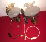 Arandelas de parede antigas, feitas de metal trabalhado com cúpulas de vidro opalina.