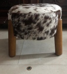 Puff Barril pequeno feito de couro legítimo com pelo bovino com pés em madeira.