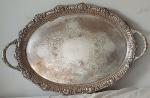 Antiga e grande bandeja ao gosto português, metal com banho de prata, fundo fartamente cinzelado com folhas de Acanto e volutas. Borda recortada e cinzelada com folhas de Parreiras e cachos de Uvas. Alças laterais. Medidas:  57.5 x 37 cm. (Precisando de banho de prata)