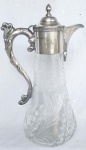Linda jarra em cristal, com decorações em baixo relevo e alto relevo representando folhagem e flores, gargalo e alças em metal com banho de prata. Apresenta contraste e monograma. M  Medidas: Alt. 29 x 17 x 12 cm.