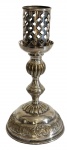 Castiçal em metal prateado com base trabalhada e corpo torneado, acompanhado de peça vazada e removível. Medindo: 23,5 x 27 cm.