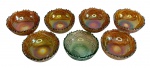 Carnival glass - Sete bowls para sobremesa em vidro, com acabamento iridescente e bordas onduladas. Medindo: 10,5 x 4,5 cm.