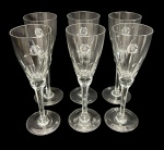 Seis taças de champanhe em cristal translúcido com decoração gravada e monograma. Medindo: 20 x 6,5 cm.