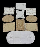 Conjunto com 10 peças variadas em tecidos e rendas. Lote composto por peças decorativas como toalhinhas e centros de mesa em diferentes formatos, com trabalhos em renda, bordado e tecido liso, apresentando variações de tamanhos e estilos. Itens em bom estado geral, podendo apresentar leves sinais do tempo.